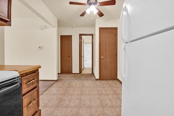 A kitchen with a refrigerator on the right side.